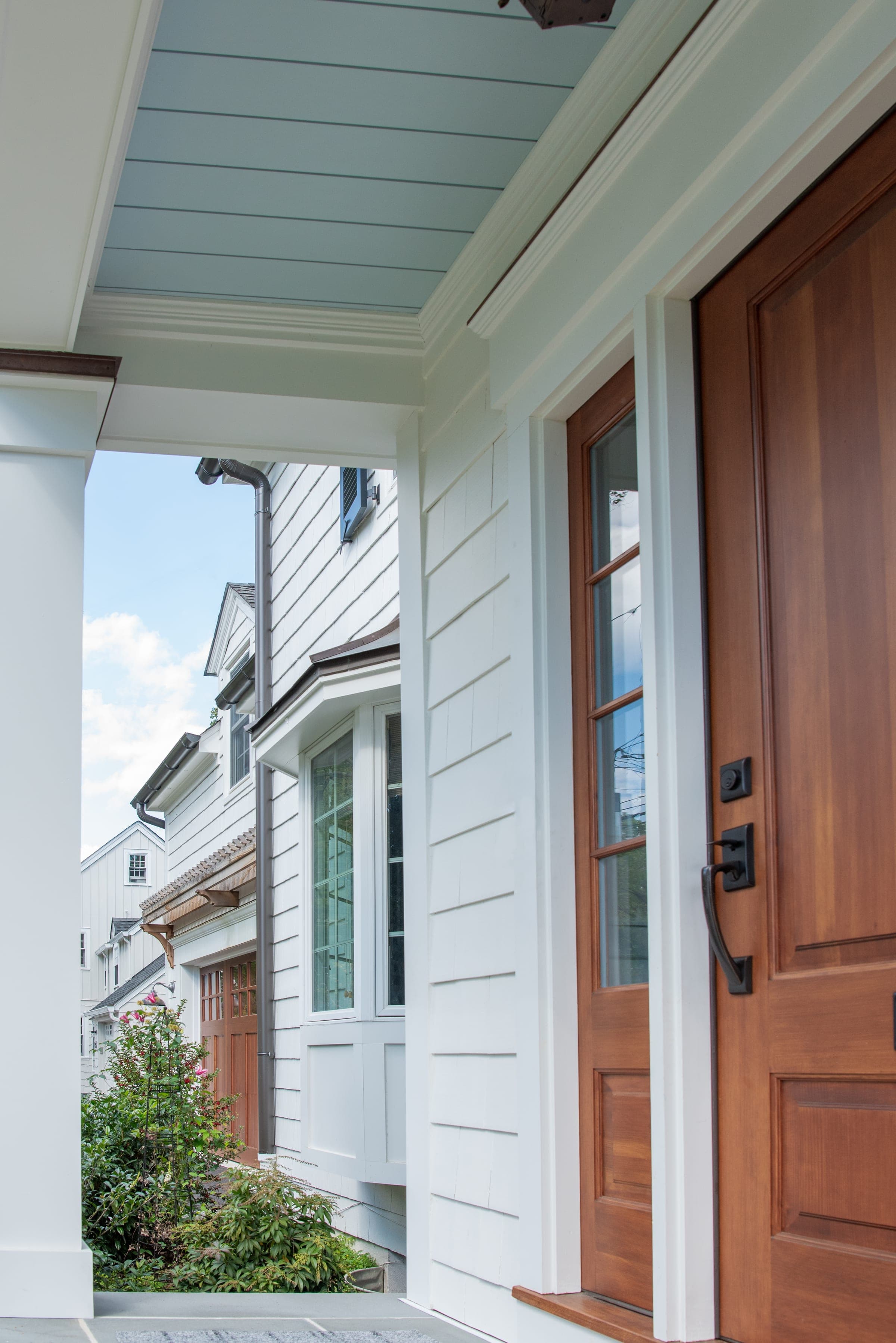 Front porch and cedar door details on a Colonial Revival exterior renovation in Westfield, NJ by Ellie Mroz Design.